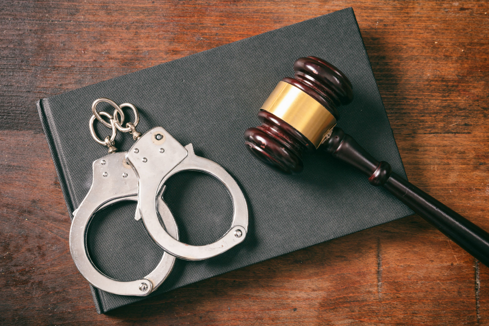 Handcuffs gavel on book on a wooden background 7msxj86 min